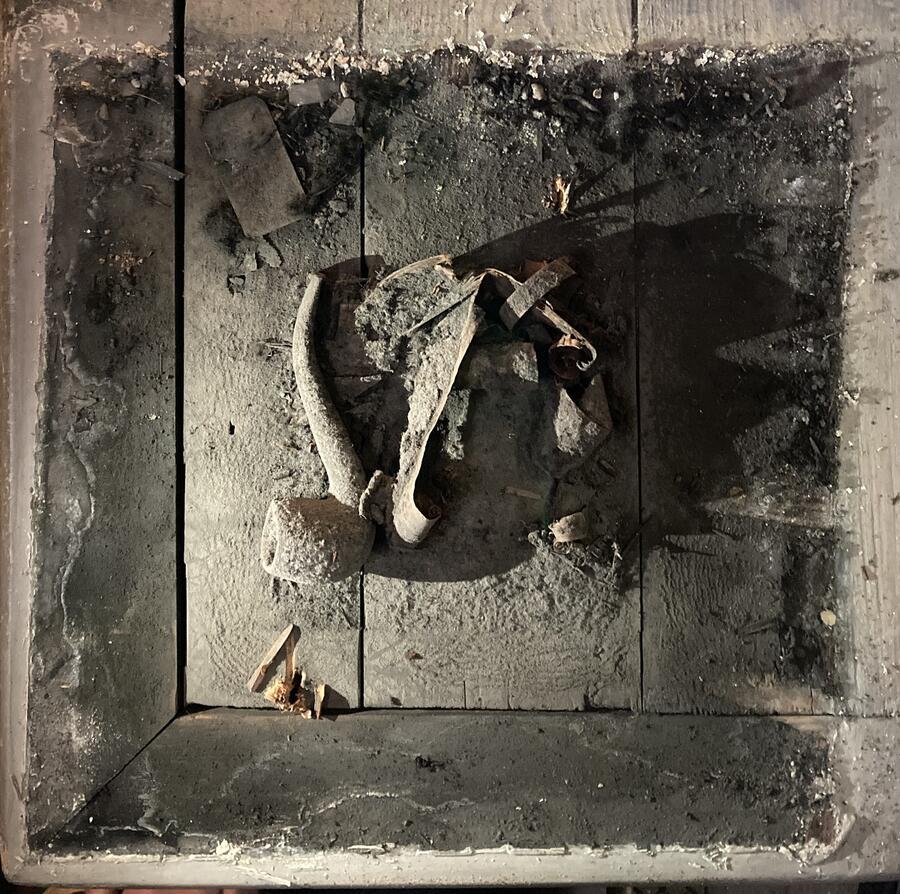 The time capsule as discovered; the pipe, shavings and ticket within the dust and imprint of the former column.